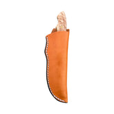 Beavertail Skinning Knife in a tan sheath, with its Birdseye Maple handle exposed.