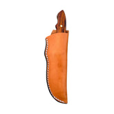 Beavertail Skinning Knife in a tan sheath, with its Cocobolo handle exposed.