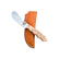 Beavertail Skinning Knife with a Birdseye Maple handle, resting diagonally across a tan shea