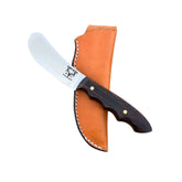 Beavertail Skinning Knife with an Arizona Desert Ironwood handle, resting across a tan sheath.